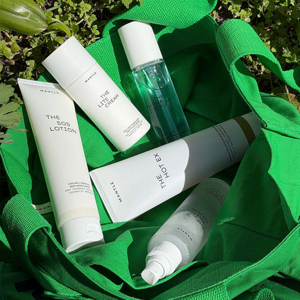 Still life image of skincare products from MANTLE in an open green tote bag